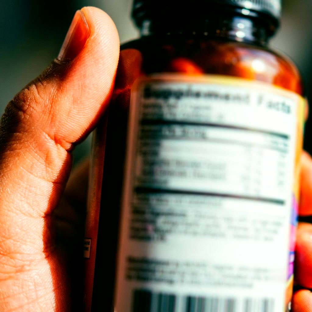 Hand turning a supplement bottle to read the back label